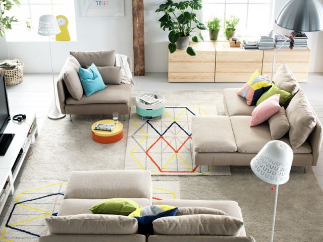 Des tapis aux tons clairs et aux lignes géométriques de couleurs sont posés dans un salon