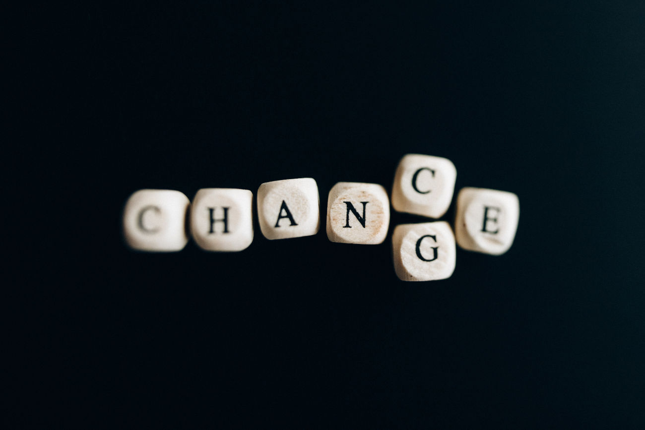 Des lettres de Scrabble sur fond noir forment le mot change