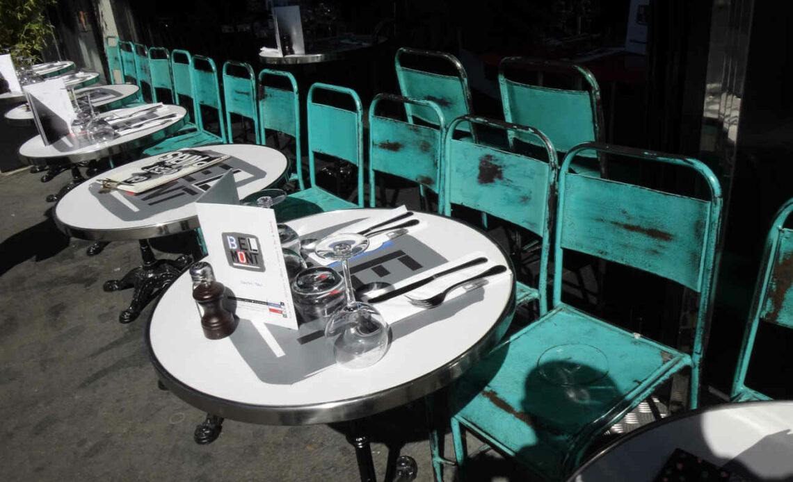 La terrasse d'un café parisien avec des tables et des chaises alignées