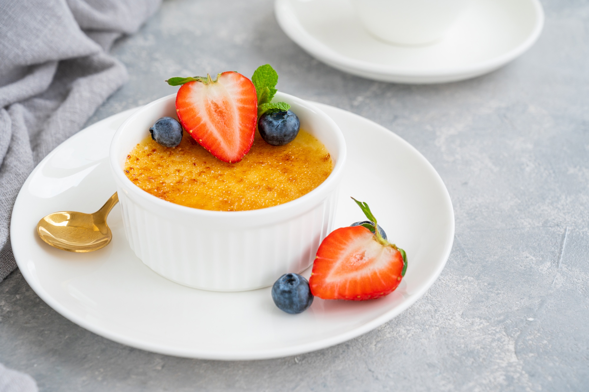 Creme brulee. Traditional French vanilla cream dessert with caramelised sugar and fresh berries